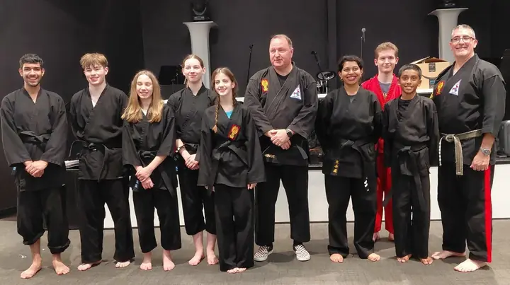 Some of the Fulshear Family Karate black belts in black uniforms with Sensei Robbie Gorringe and Master Wade Kirkpatrick